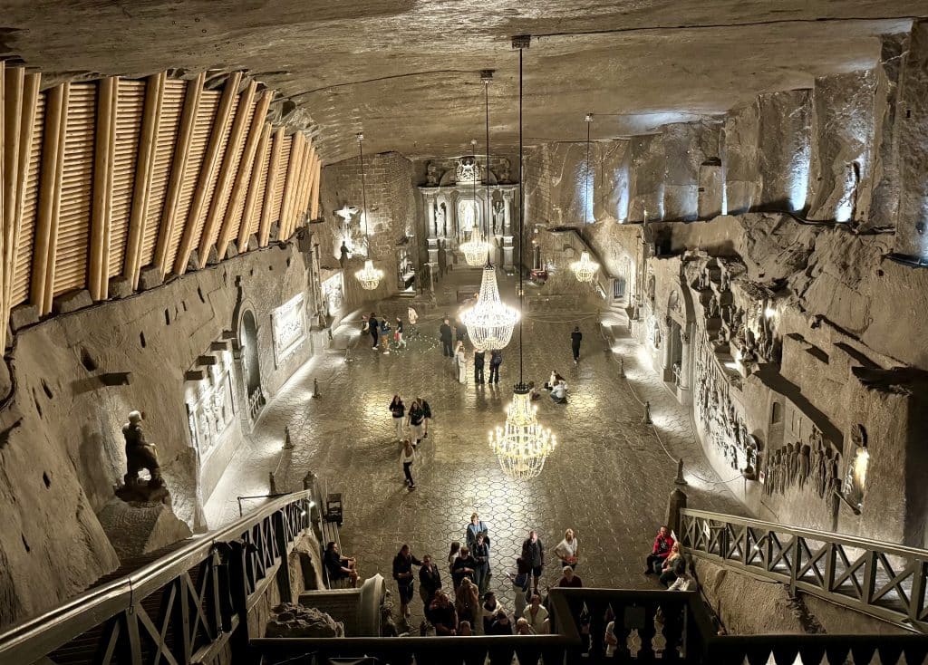 A huge, cavernous ballroom cut out of giant slabs of salt in the Polish salt mine. Some chandeliers hang from the ceiling.