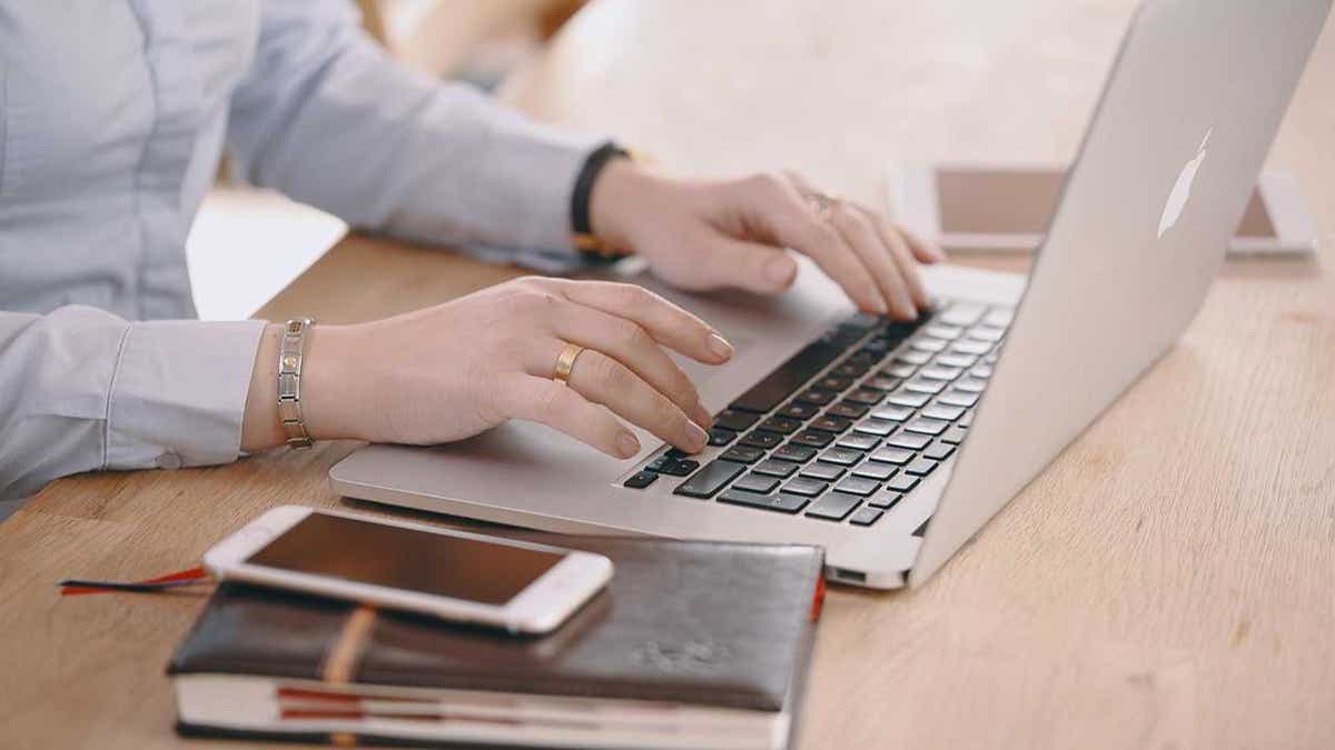 A woman types on her laptop.