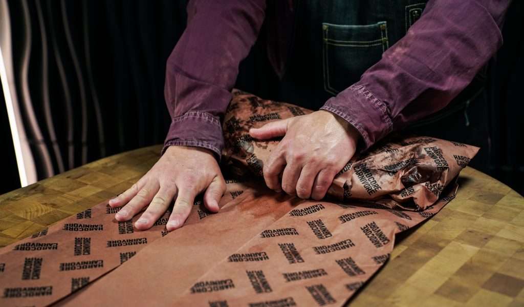 gently pull the brisket towards you to tighten the paper
