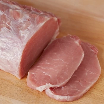 A sliced raw pork loin on a cutting board