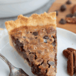 Titled image of a slice of keto chocolate chip cookie pie on a white plate.