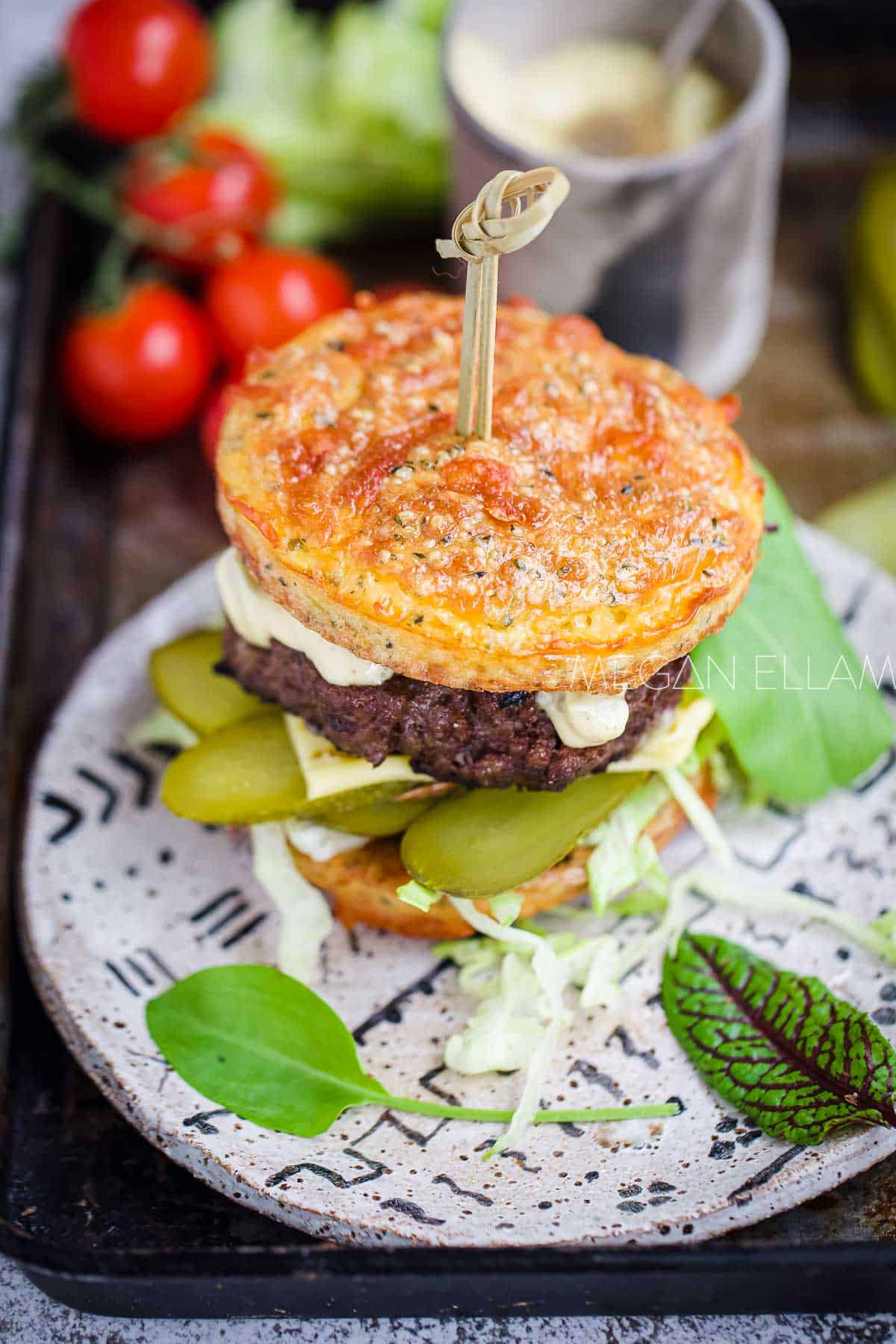 A burger and salad on a grey plate.