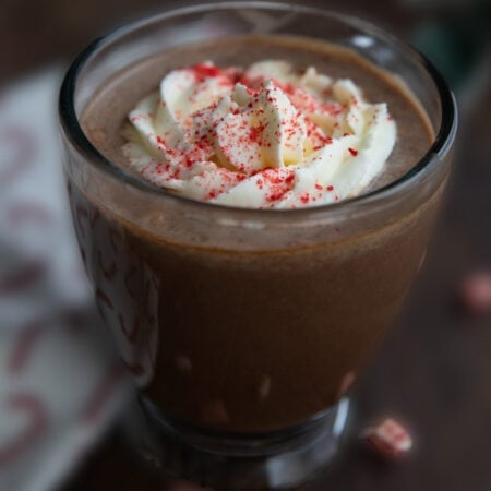 Keto Peppermint Protein Mocha in a glass mug with whipped cream on top.