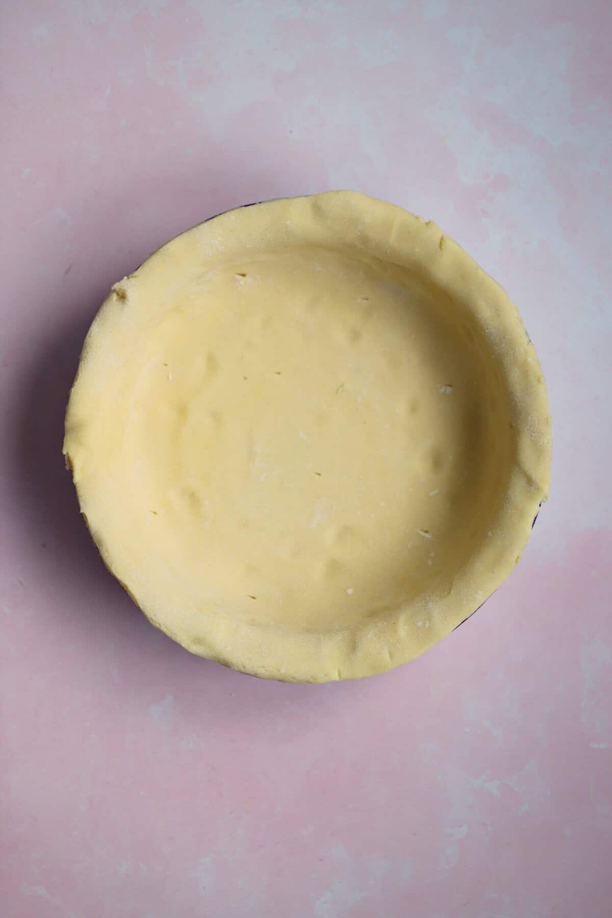 Process shot of a minced beef pie showing the pastry rolled out into a dish ready to be filled.
