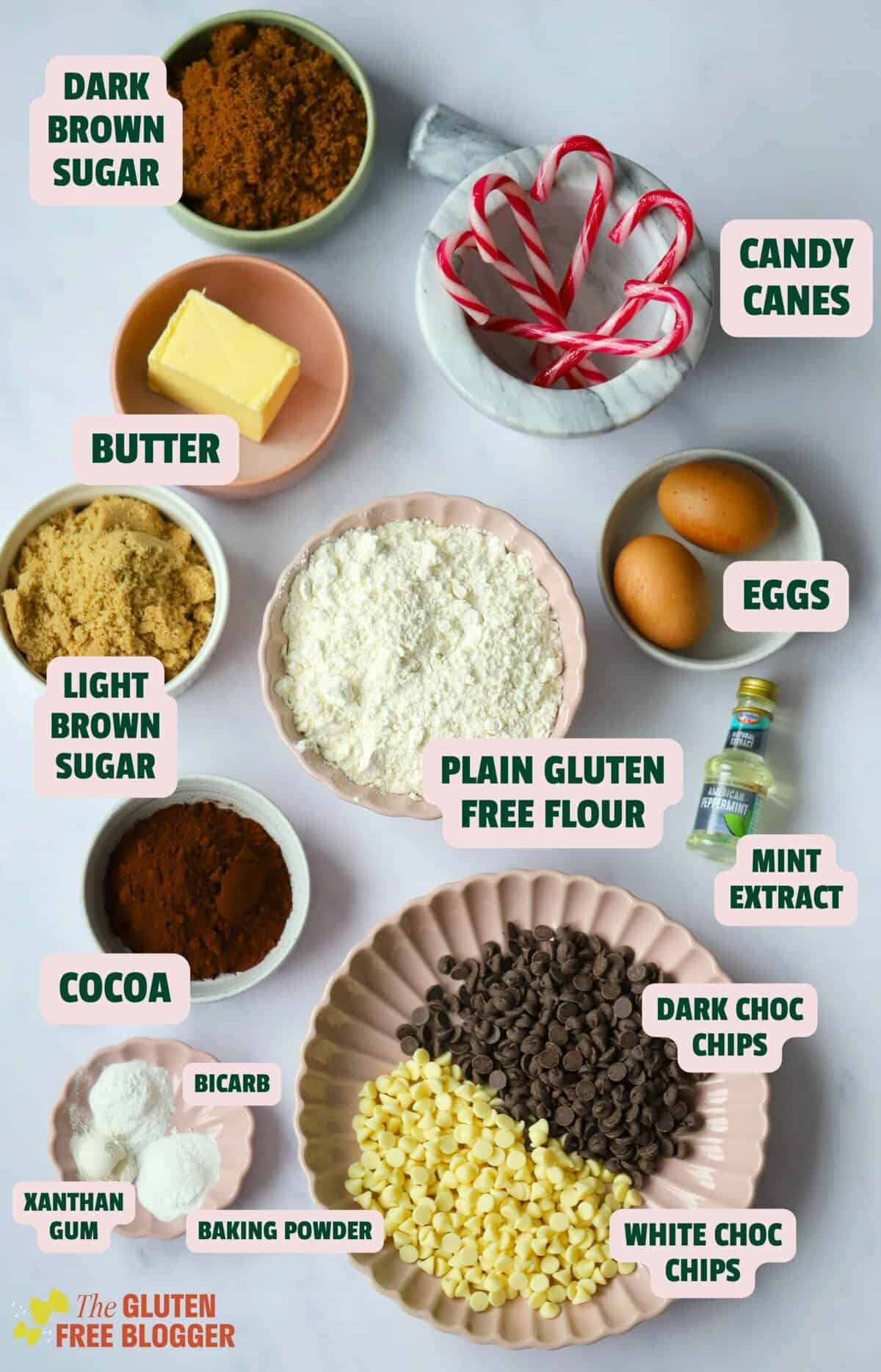 Ingredients for peppermint bark cookies including gluten free flour, sugars, butter, cocoa, eggs, candy canes and chocolate chips.