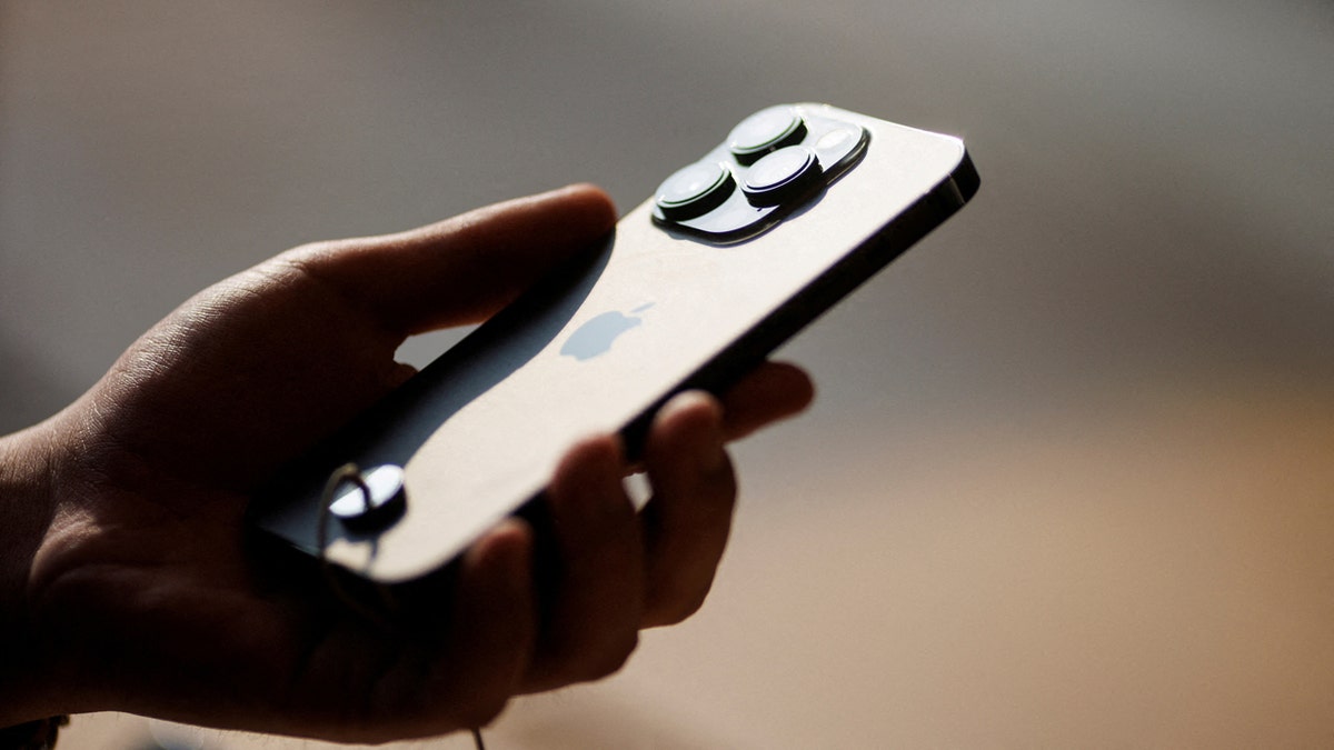 A man holds an iPhone 14