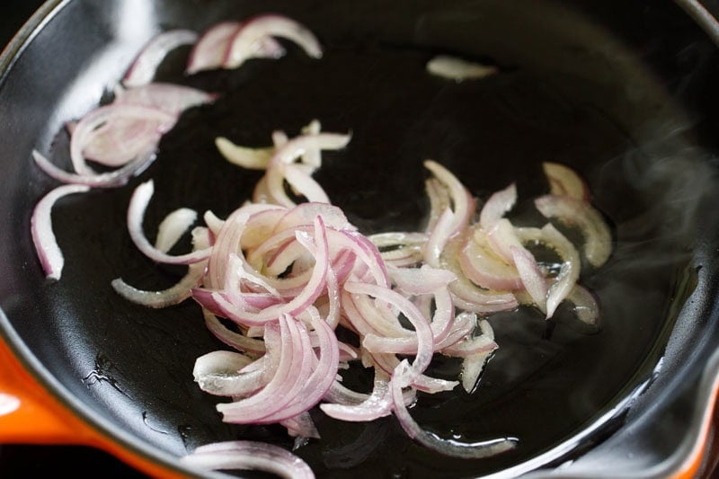 Sautéing sliced onions in a skillet.