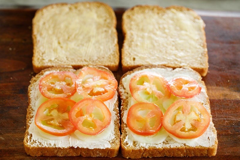 Sliced tomatoes placed on bread with cream cheese spread.