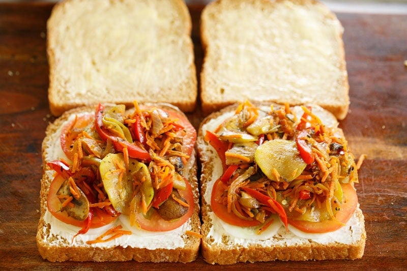 Sautéed vegetable placed on top of tomatoes on bread.