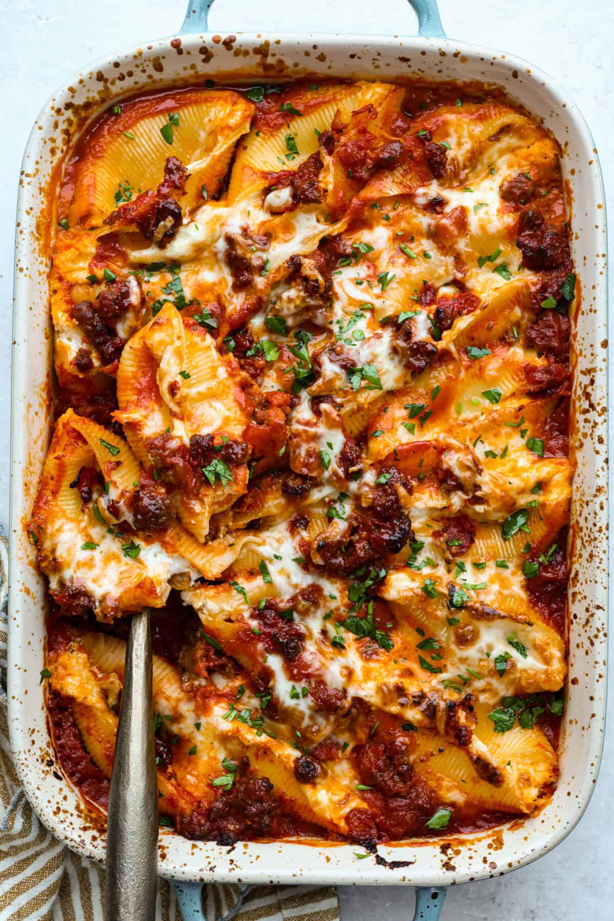 Overhead shot of the baked million dollar stuffed shells in a baking dish. 