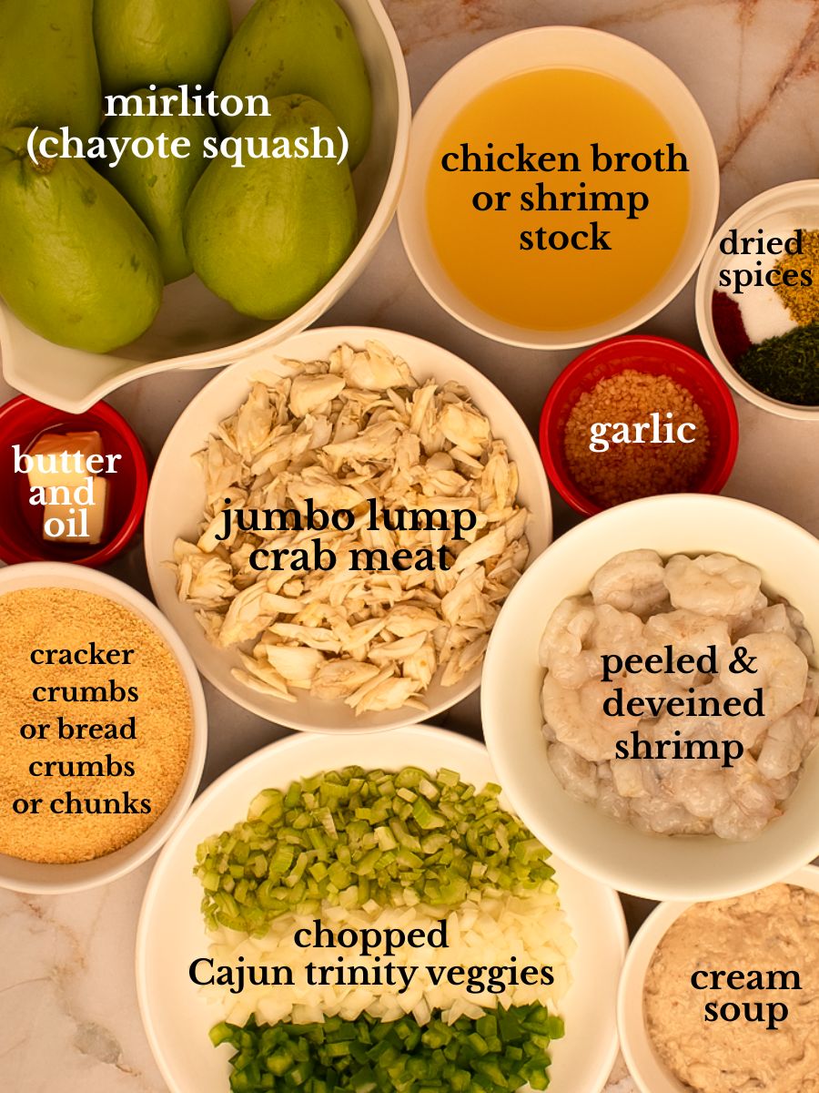 Ingredients for mirliton dressing in bowls on a white marbled background. 