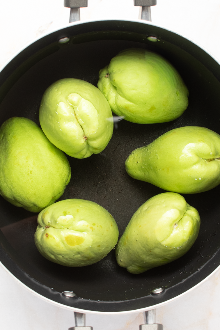 Mirliton chayote squash in a pot with water. 