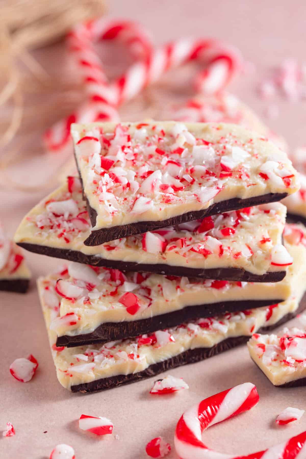 A stack of peppermint bark, which has layers of dark and white chocolate with crushed candy canes on top.