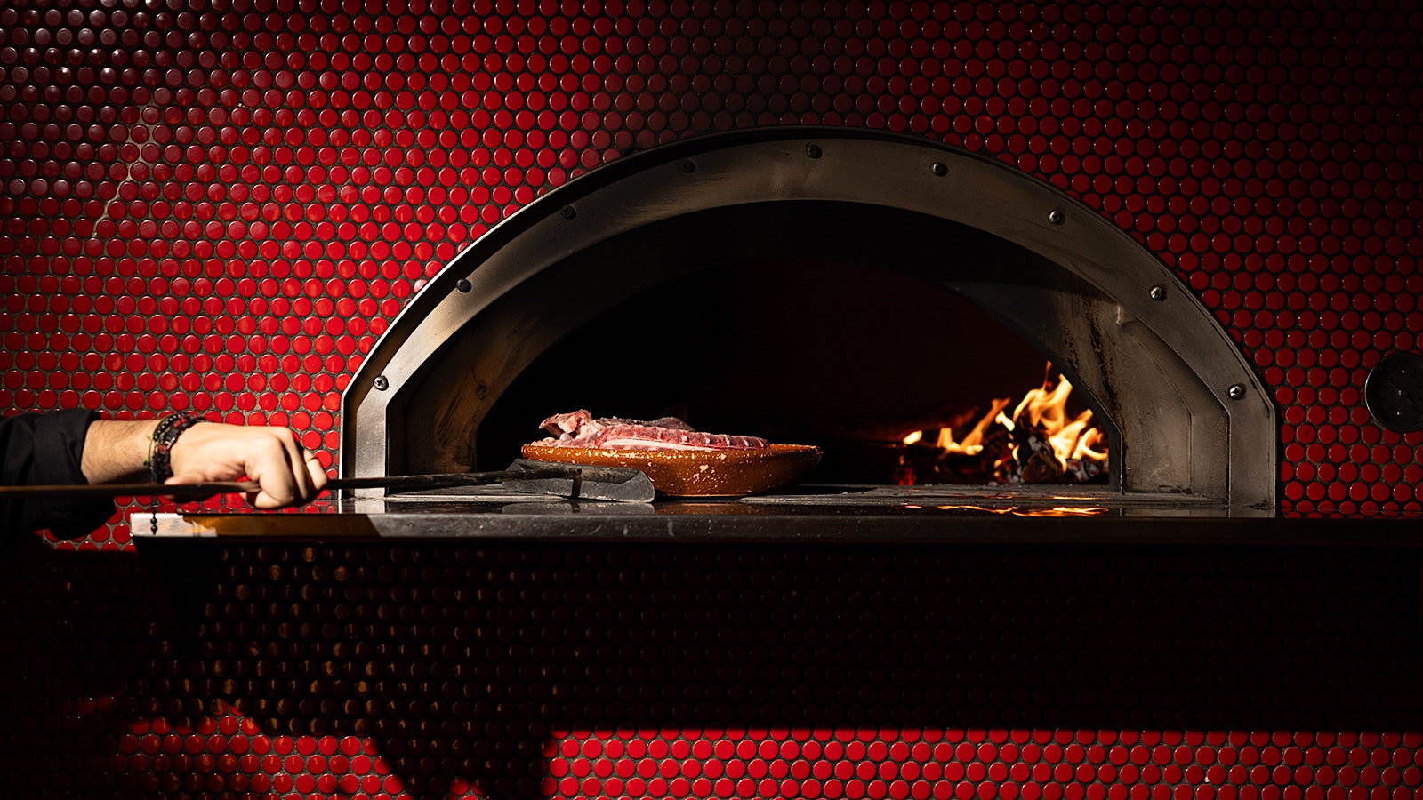  A steak cooking on a live-fire grill at Txula Steak
