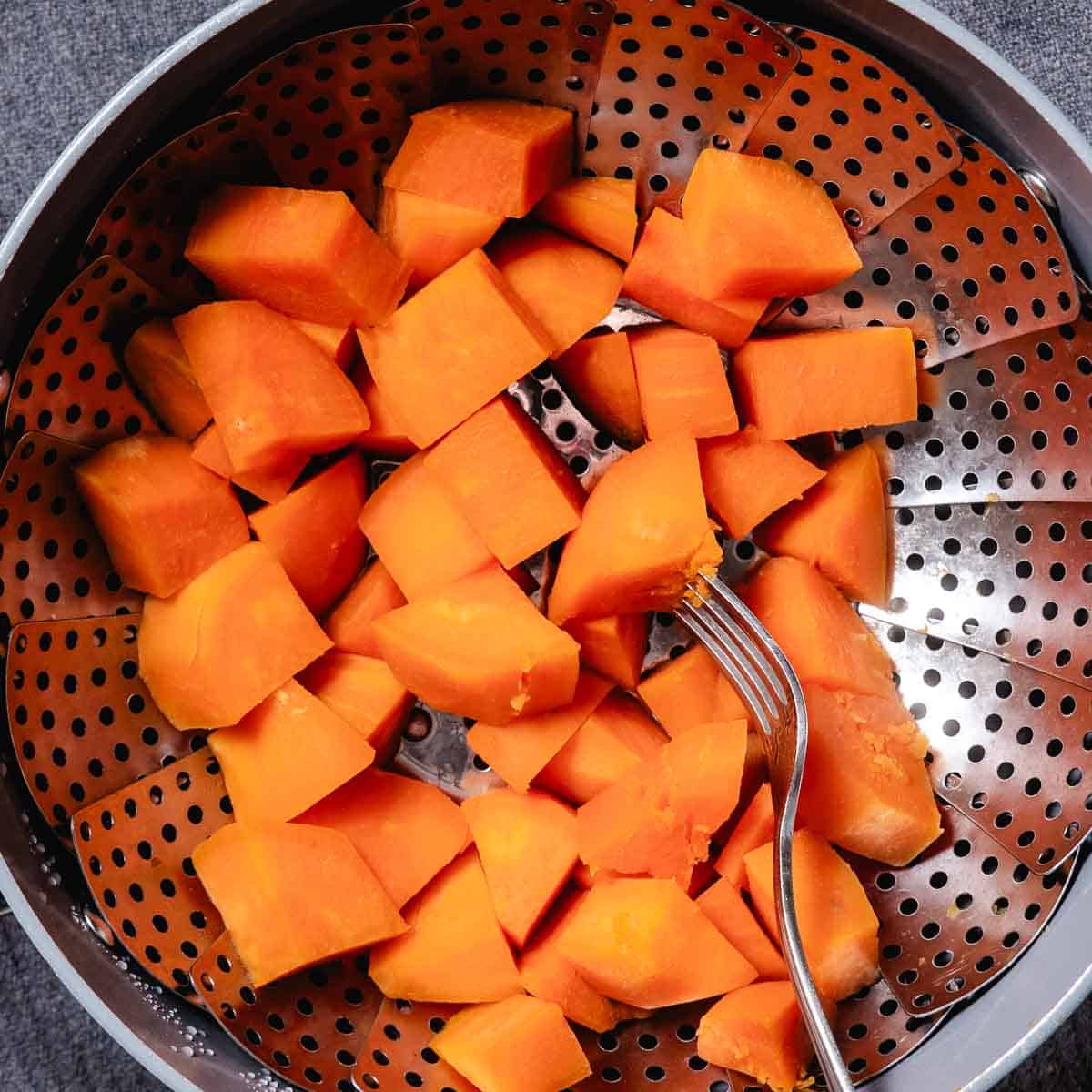 steaming sweet potato cubes in a basket