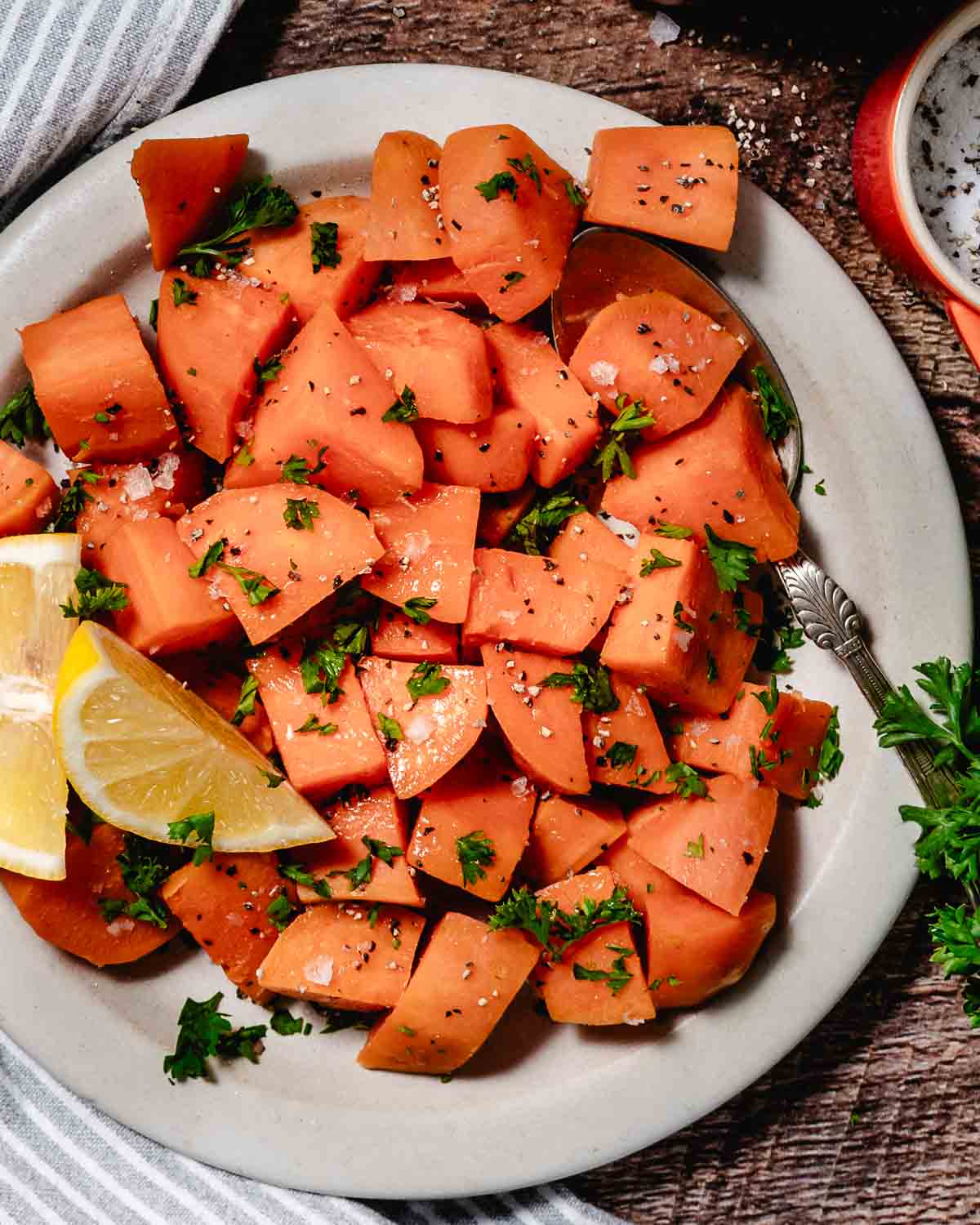 overhead image of steamed sweet potatoes with lemon and herbs