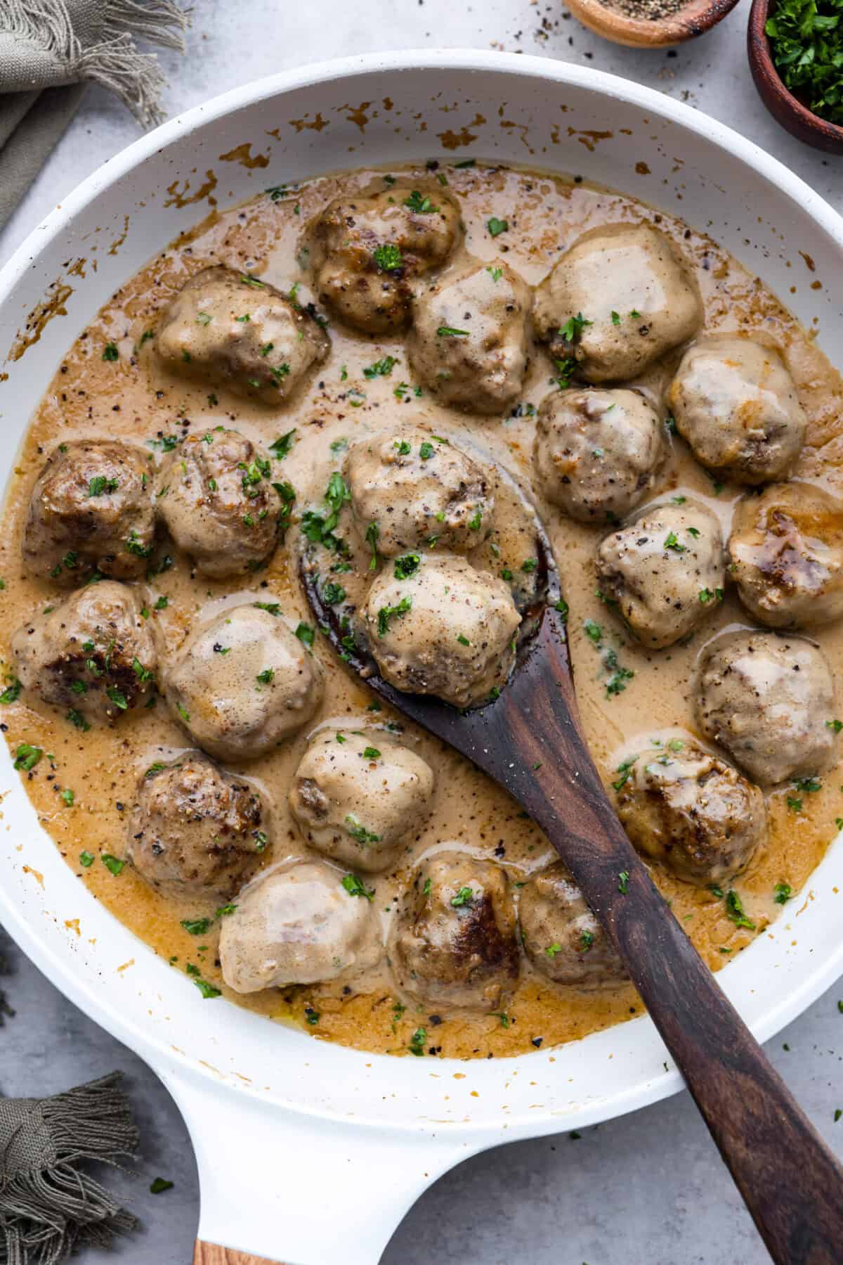 These are a top favorite recipe on the site for a reason—juicy meatballs, rich creamy gravy, and SO MUCH FLAVOR. They’re easy to make and way better than IKEA’s (yes, really!). A pan filled with cooked Swedish Meatballs with a wooden spoon.