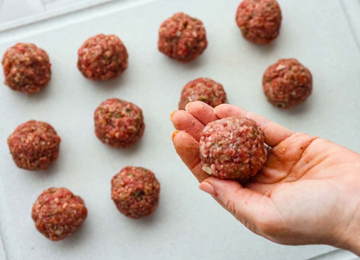 These Swedish Meatballs are smothered in the most amazing rich and creamy gravy and packed with such delicious flavor. You will quickly agree these are the BEST you have ever had! Someone rolling out the meat into balls.