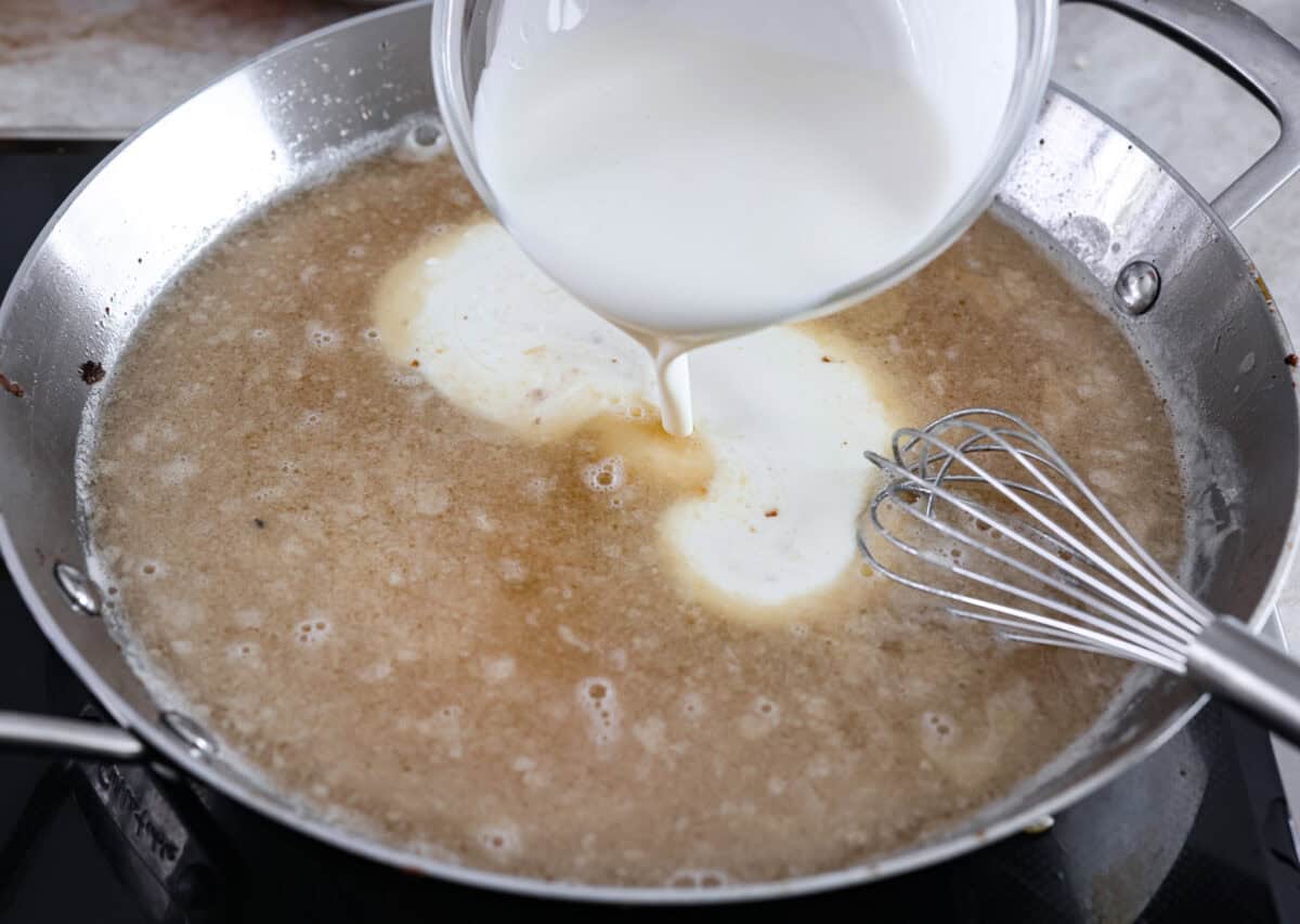 These Swedish Meatballs are smothered in the most amazing rich and creamy gravy and packed with such delicious flavor. You will quickly agree these are the BEST you have ever had! Heavy cream being added into a pan.