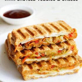 veggie sandwiches stacked on top with ketchup in a small bowl kept behind with text layovers.