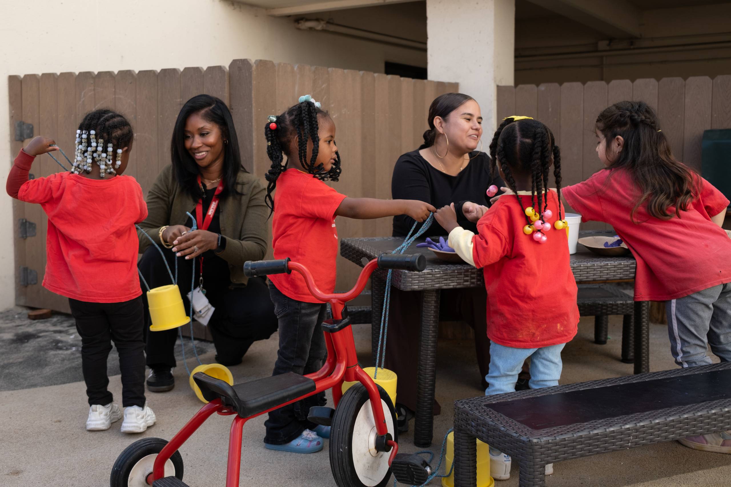 Kids work with teachers at tables