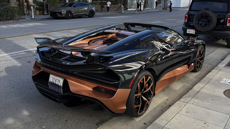 Rear 3/4 view of a black and copper Bugatti Mistral
