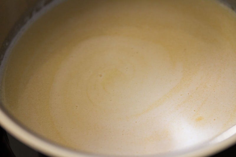Creamy liquid swirling in pot