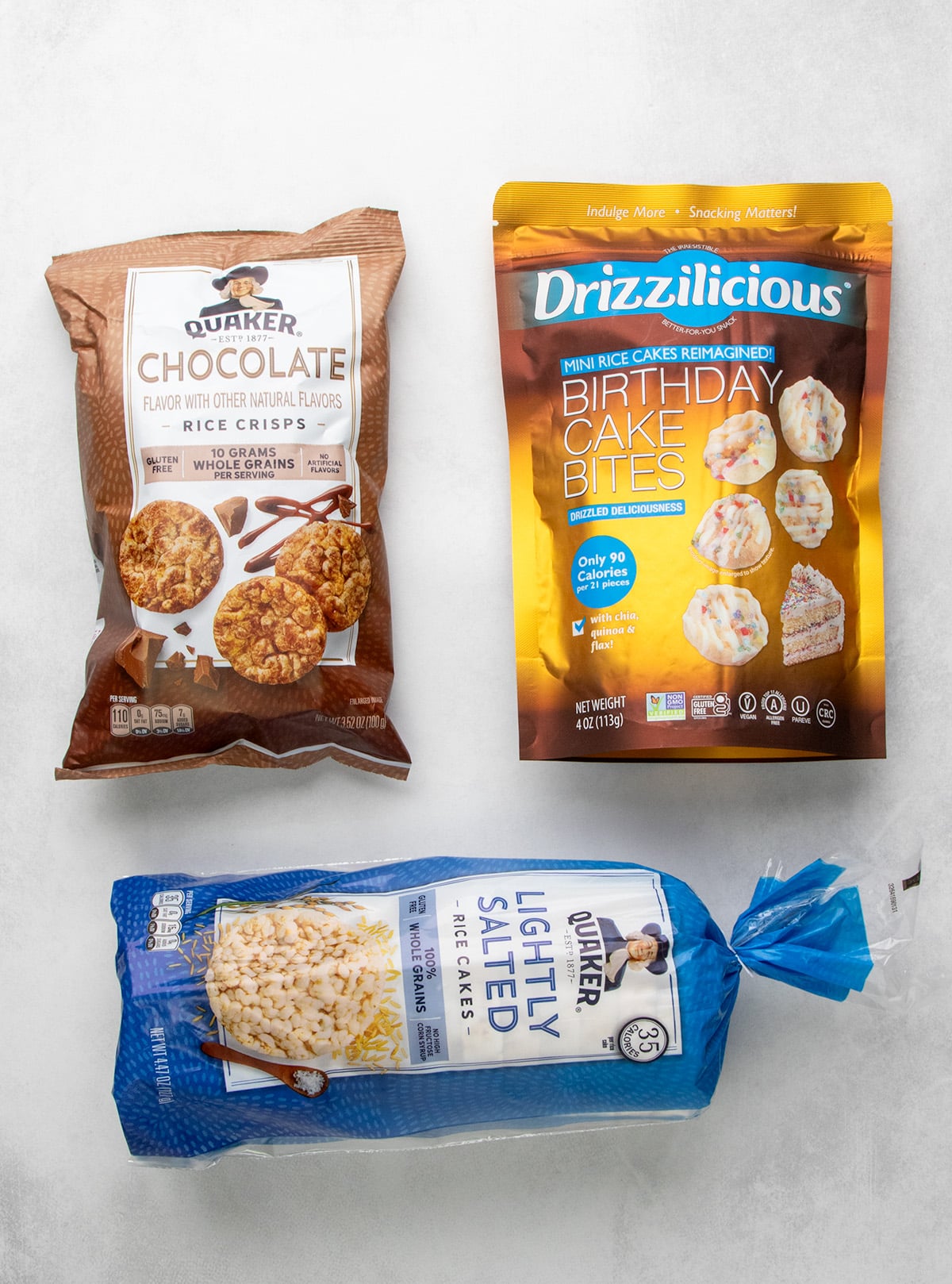 Packages of Quaker chocolate rice crisps, Drizzilicious birthday cake bites, and Quaker lightly salted rice cakes.
