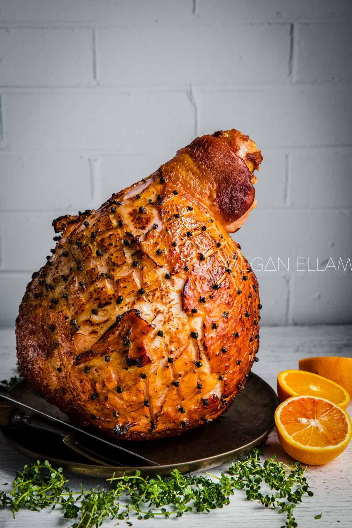 A glazed ham standing on a plate. Use it fresh or leftover ham for Easy Easter Appetizers.