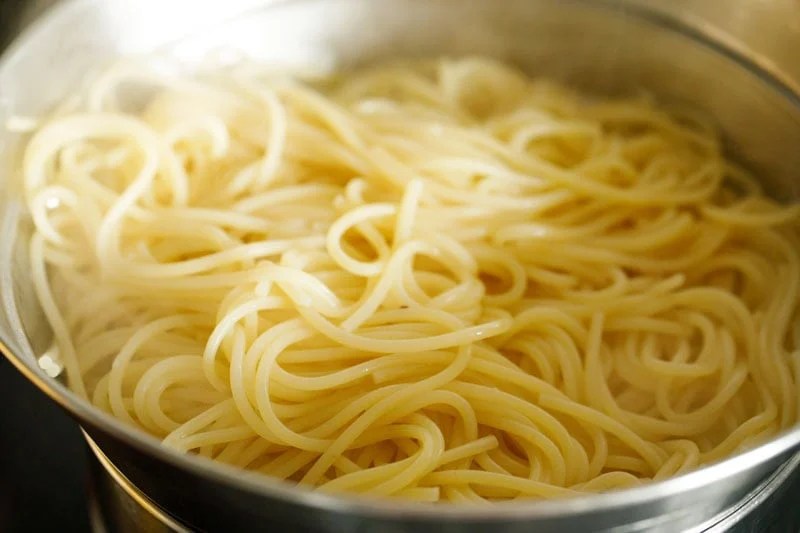 Cooked spaghetti in a strainer.