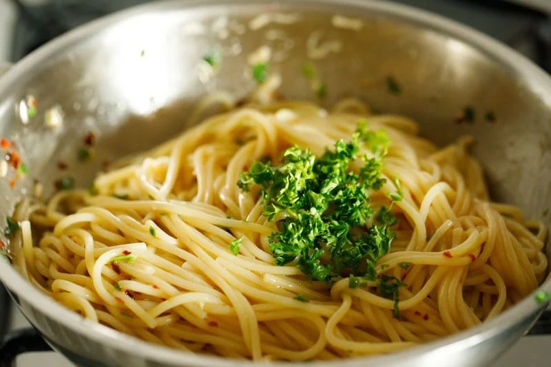 Prepared spaghetti aglio e olio with parsley garnish.