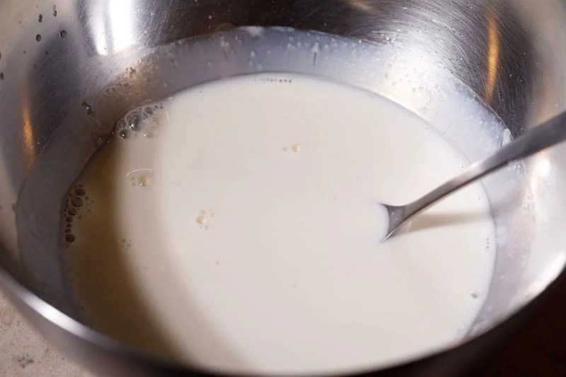 Mixing milk with vinegar with spoon.