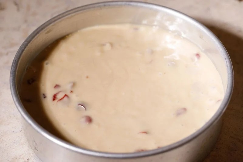 Cherry cake batter poured in prepared round cake pan.