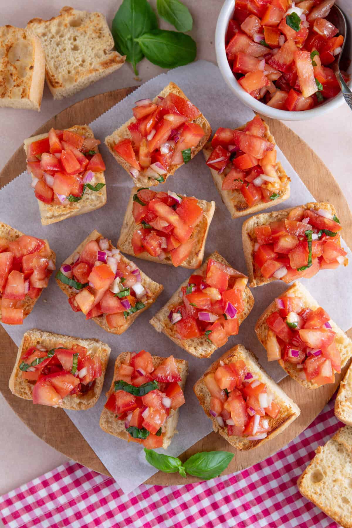 Process shot for gluten free bruschetta showing the ciabatta squares topped with the tomato mixture.