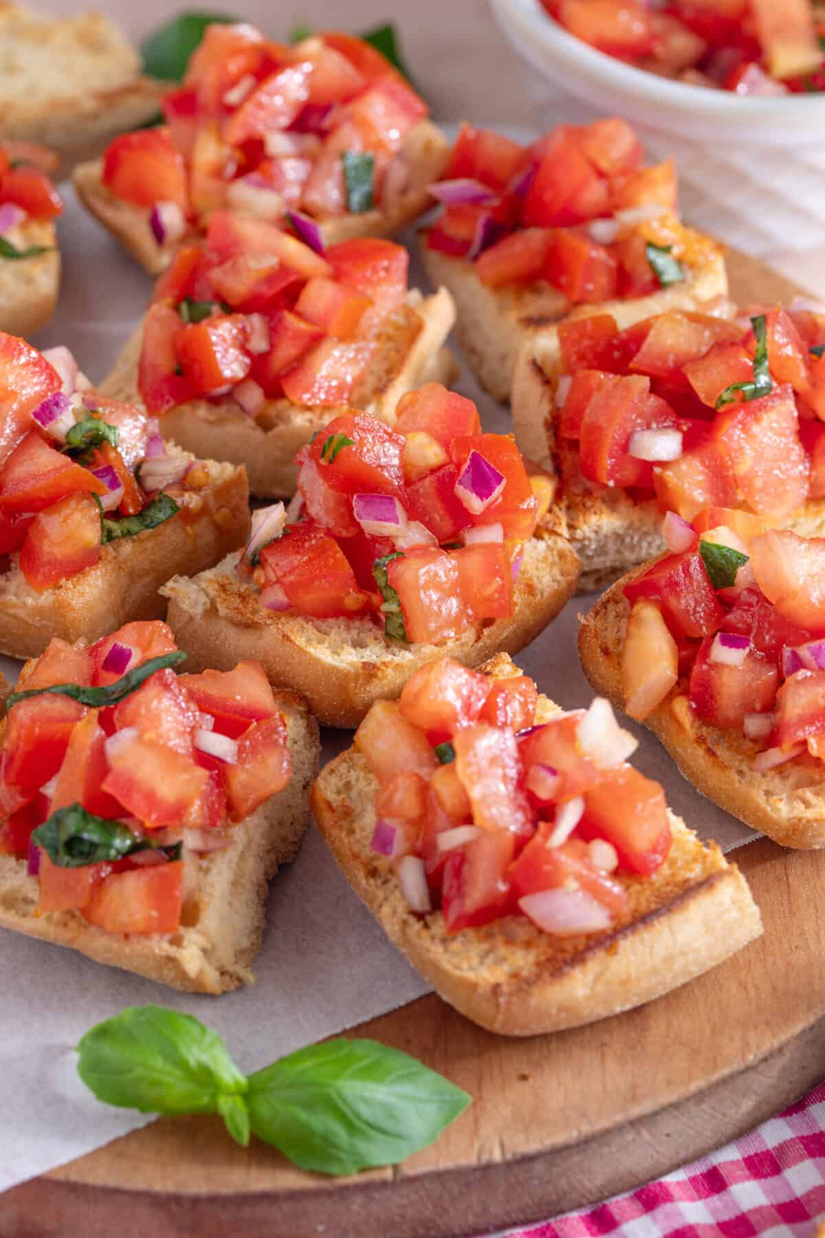 A board of gluten free bruschetta topped with tomatoes.