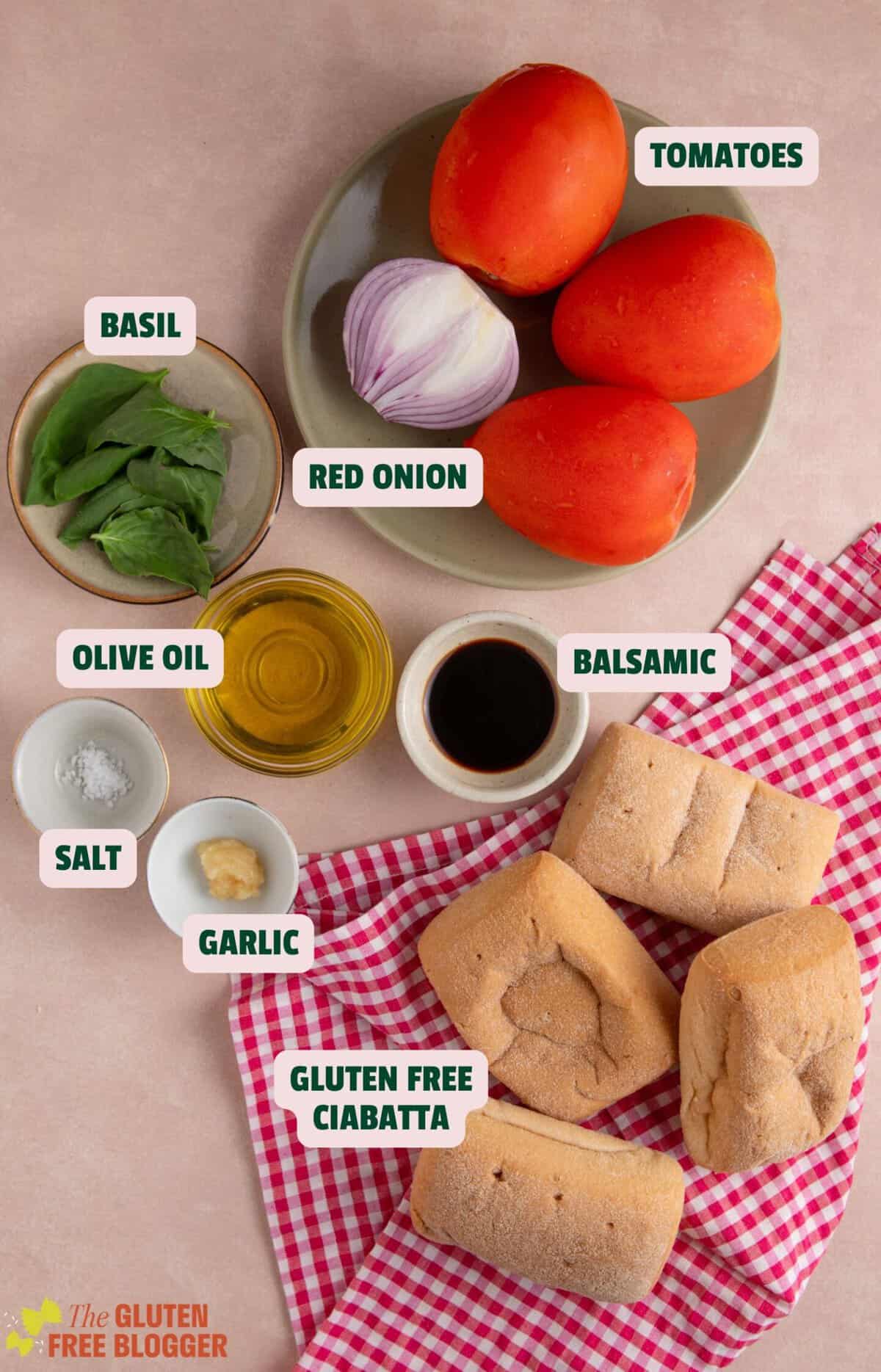Ingredients for gluten free tomato bruschetta with text labels.