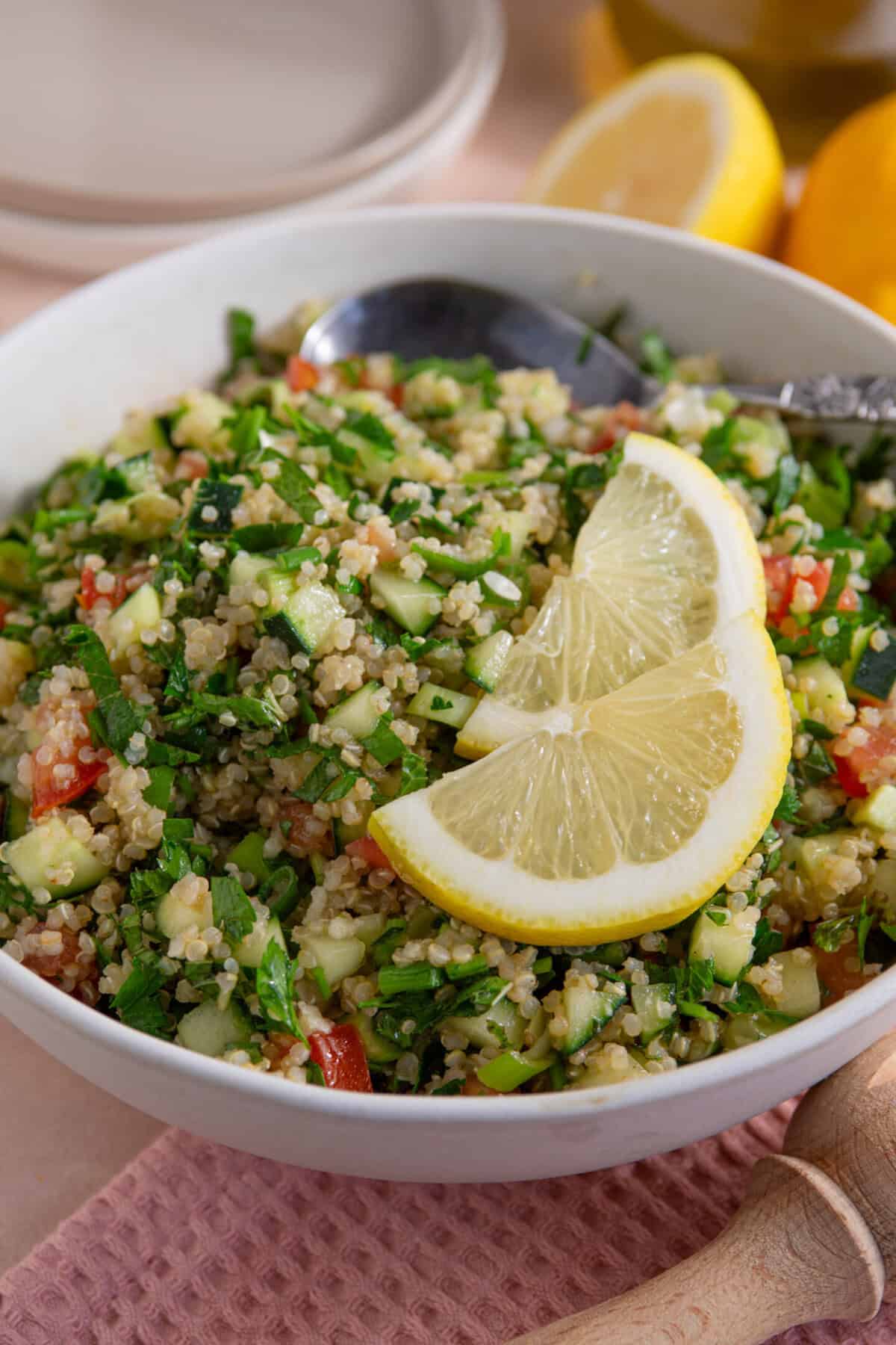 A bowl of gluten free tabbouleh with lemon slices on top.