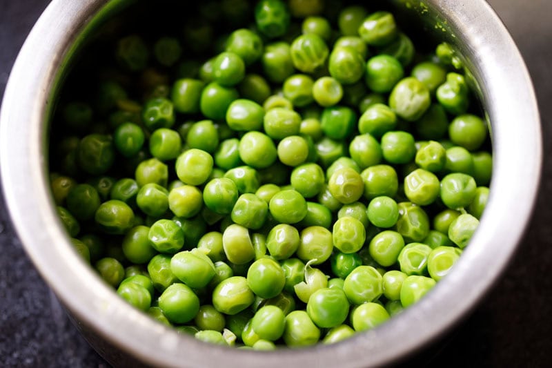 Cooked green peas in bowl.