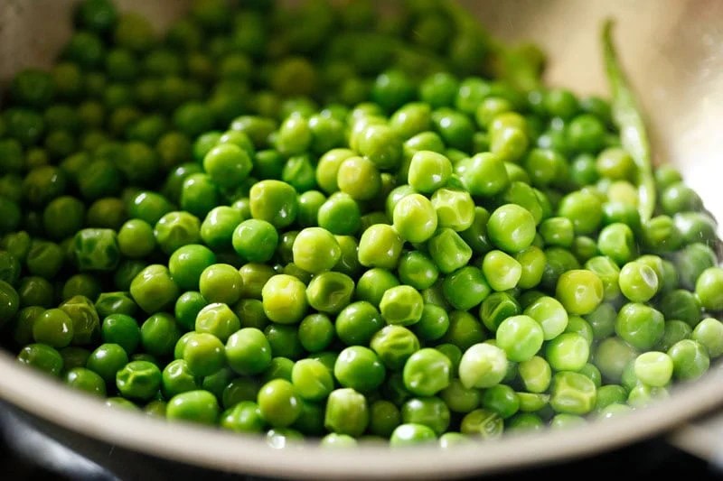 Steamed green peas or matar added to pan.