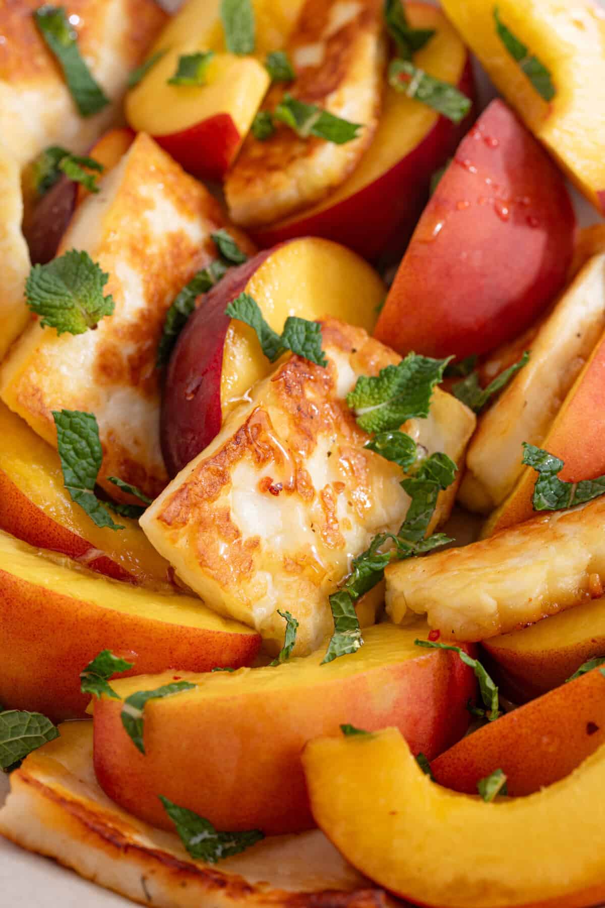 Close up of a bowl of peach and halloumi salad.