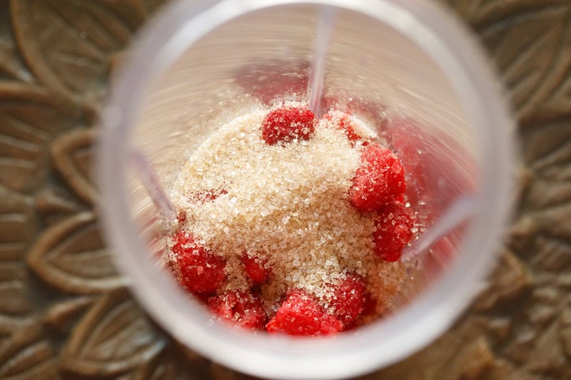 Raspberries and sugar in blender.