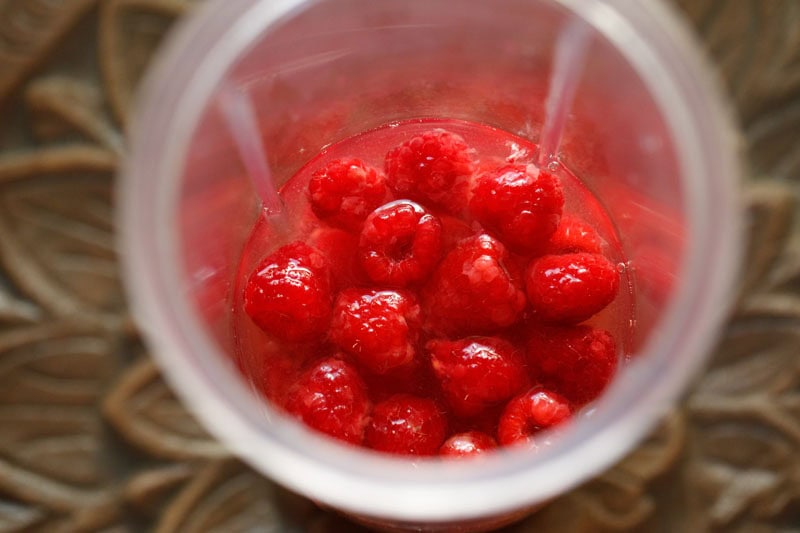 Water and raspberries in blender.