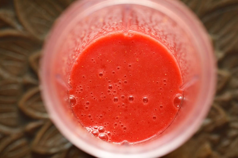 Blended raspberry juice in blender cup.