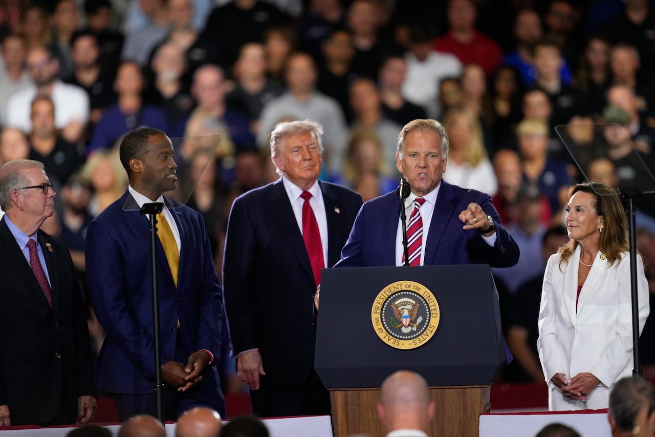 men in suits stand at podium