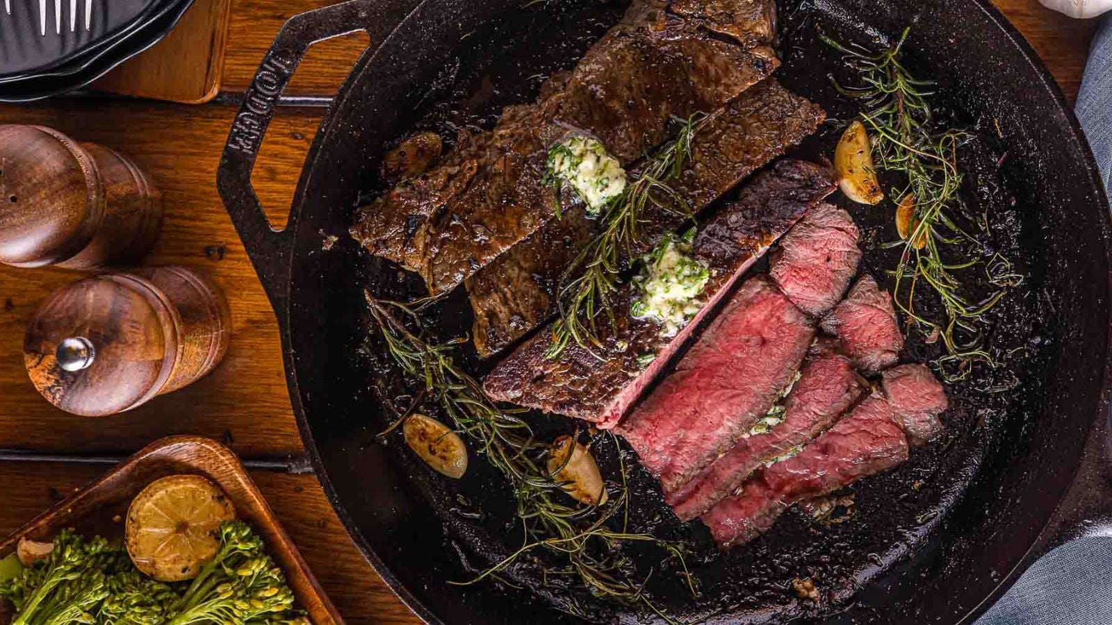 Cast iron steak with a deep sear and butter juices pooling in the pan.