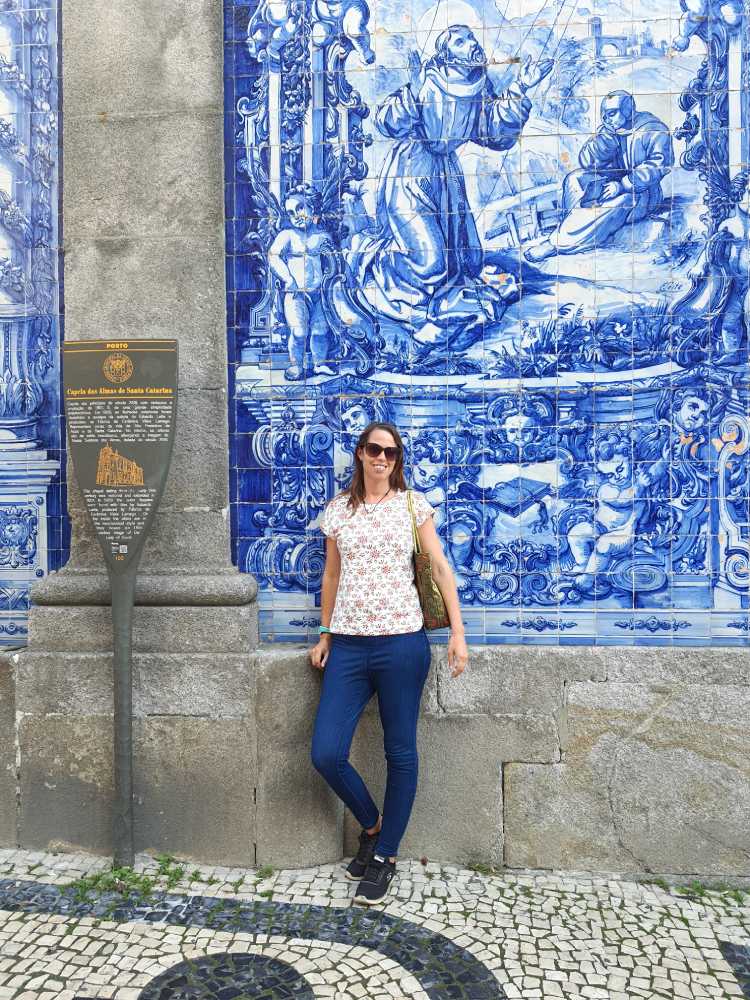 Anna standing by blue and white tiled building in Porto, portugal