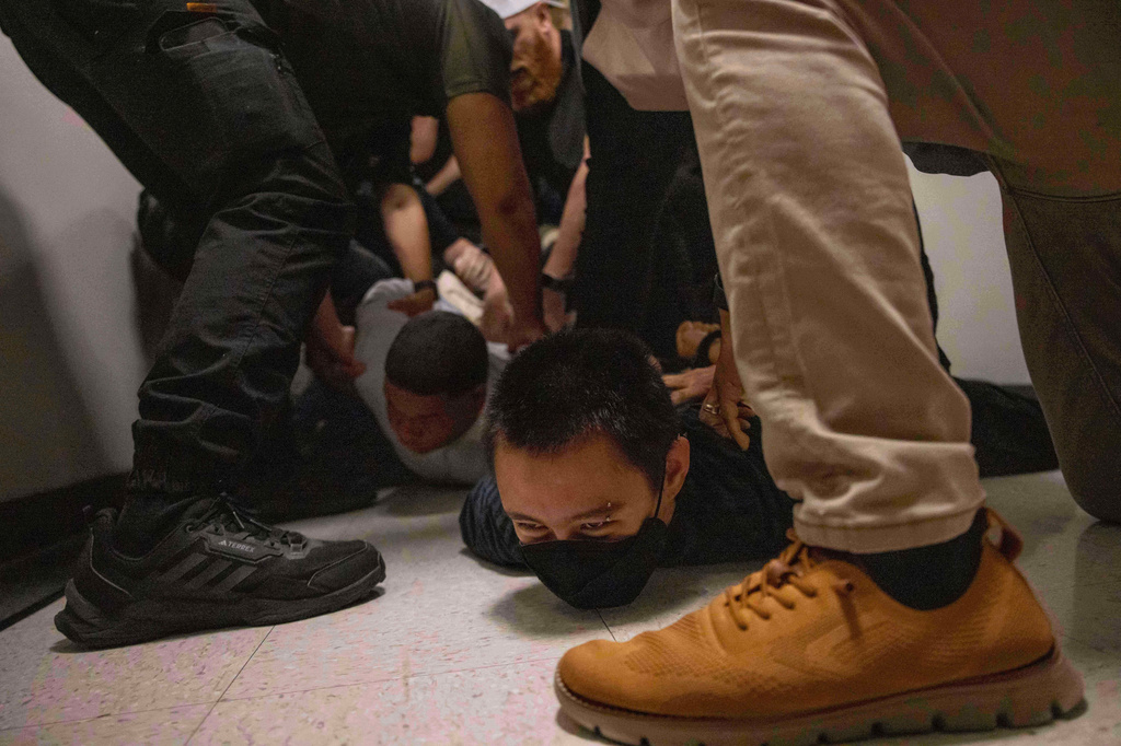 A Dominican man, left, and an activist, right, are detained by plainclothes officers with Immigration and Customs Enforcement after an immigration hearing at the immigration court inside the Jacob K. Javits Federal Building in New York, on June 6, 2025.