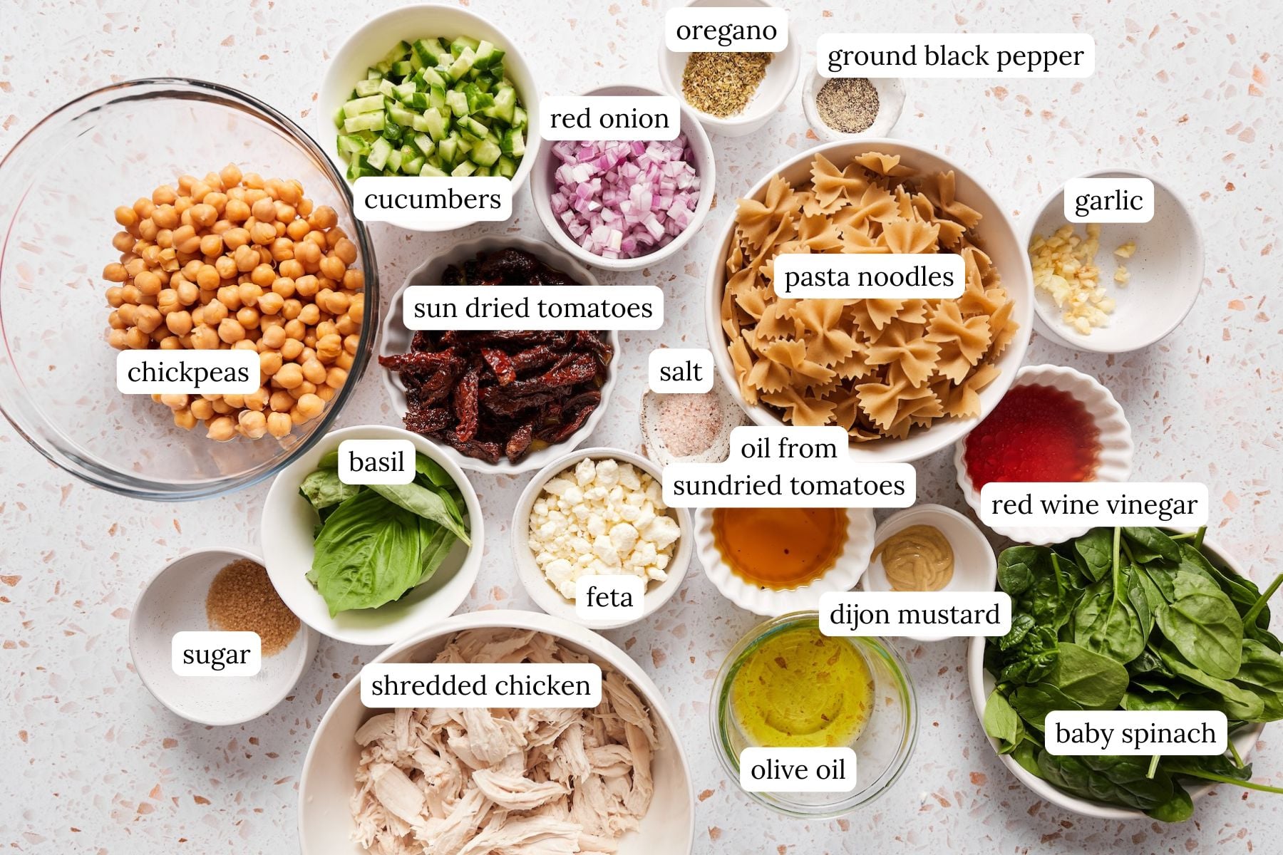 Chickpea pasta salad recipe ingredients laid out in bowls and labeled.