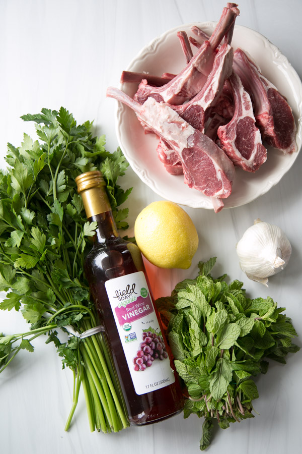 ingredients for lamb with mint sauce on a counter - lemon garlic mint parsley red wine vinegar