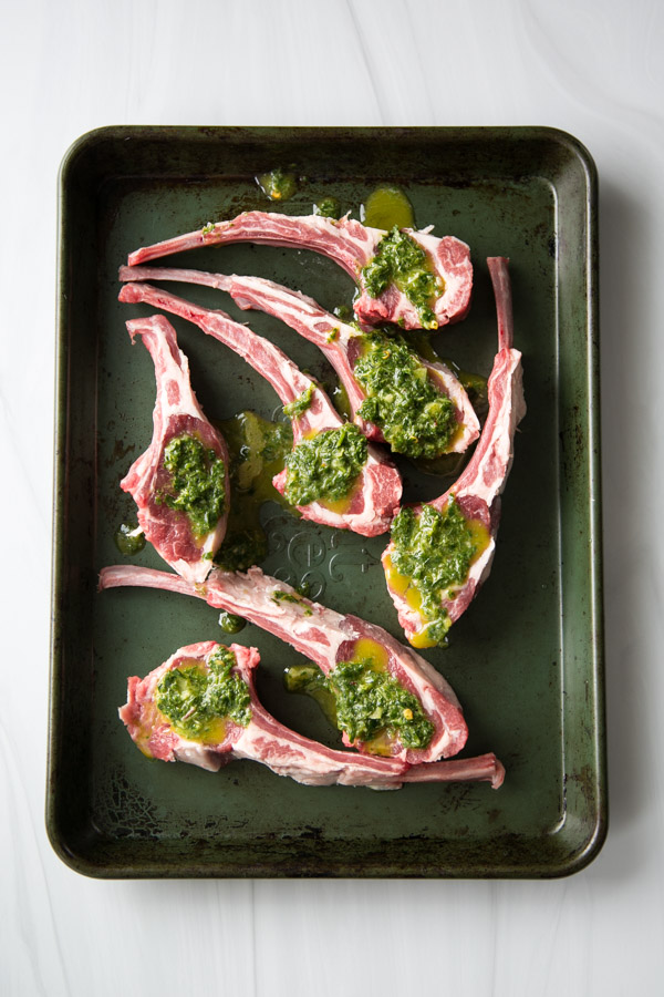 lamb rib chops with mint marinade on top on a baking dish